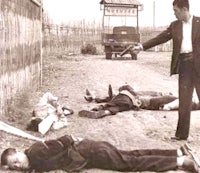 a group of men laying on the ground next to a truck