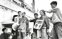 a group of people holding signs in front of a building